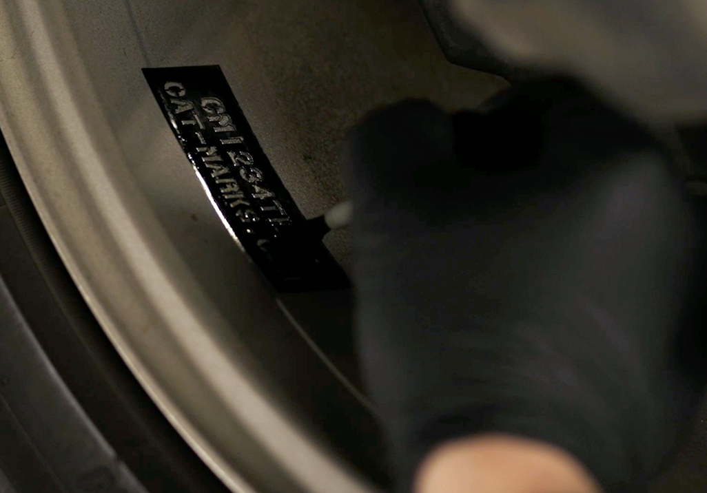 Close-up image of a hand applying the UV Wheel coating to a stencil.